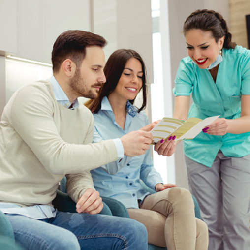 Dentist smiling as they help patient with dental insurance